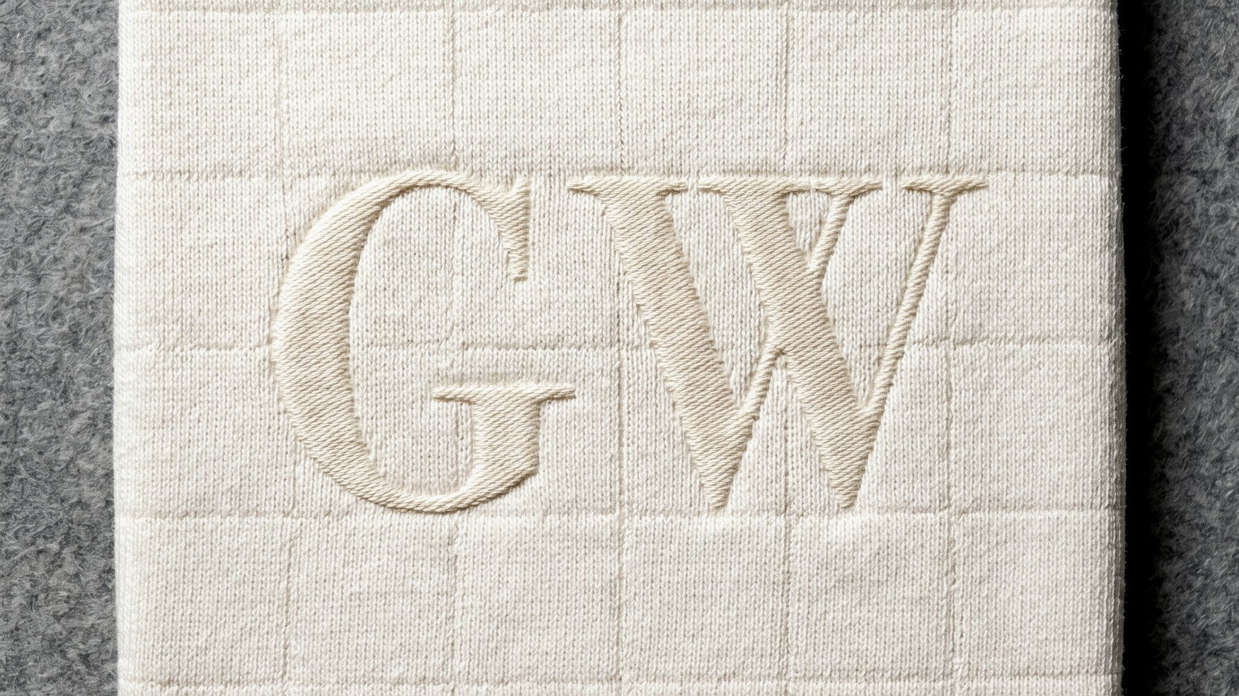 A folded moon-white knit with tonal GW satin-stitch embroidery.