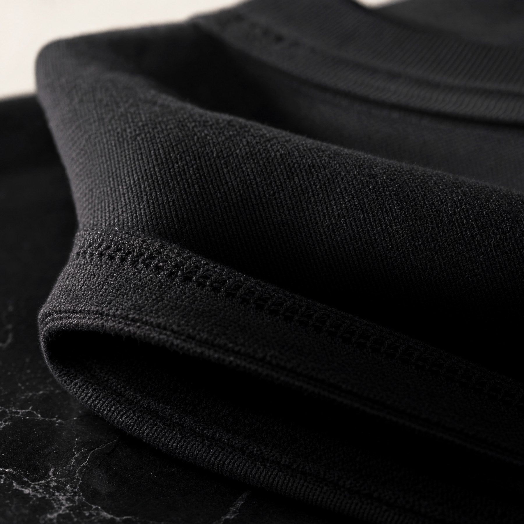 A macro of obsidian cotton ribbing in raking light.